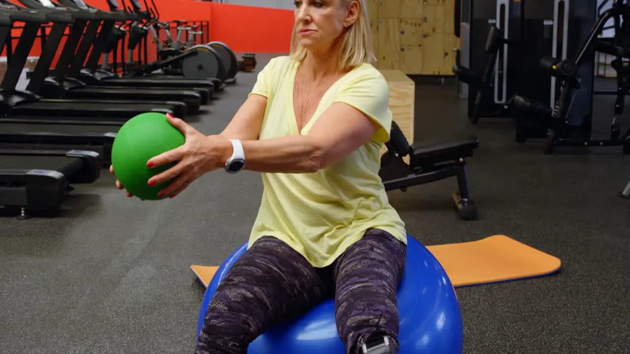 Senior woman doing abs workout with exercise ball 4k