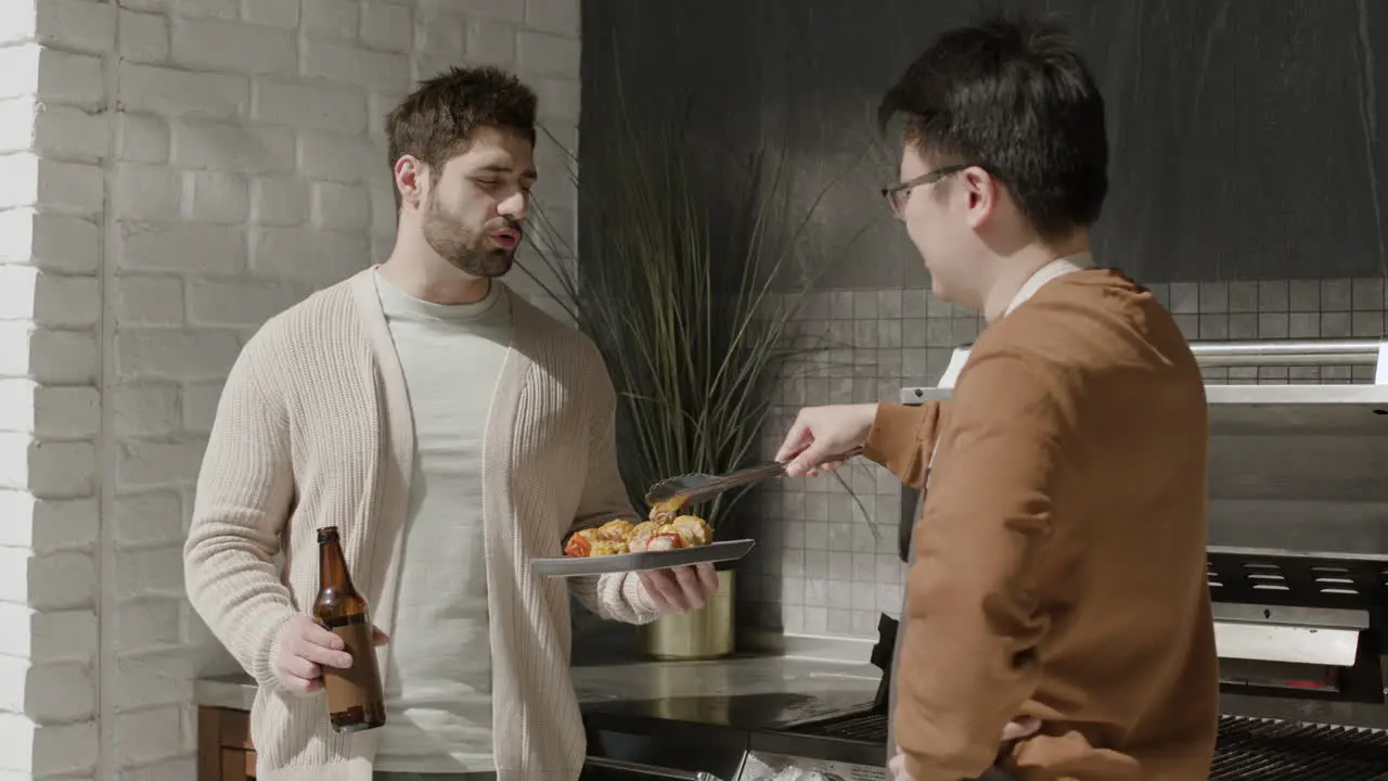 A Young Guy And His Friend Talking While Having A Barbecue 2