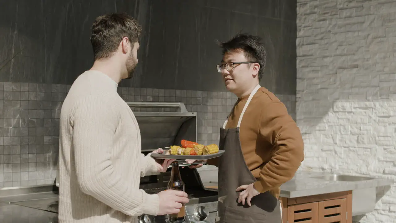 A Young Guy And His Friend Talking While Having A Barbecue 1