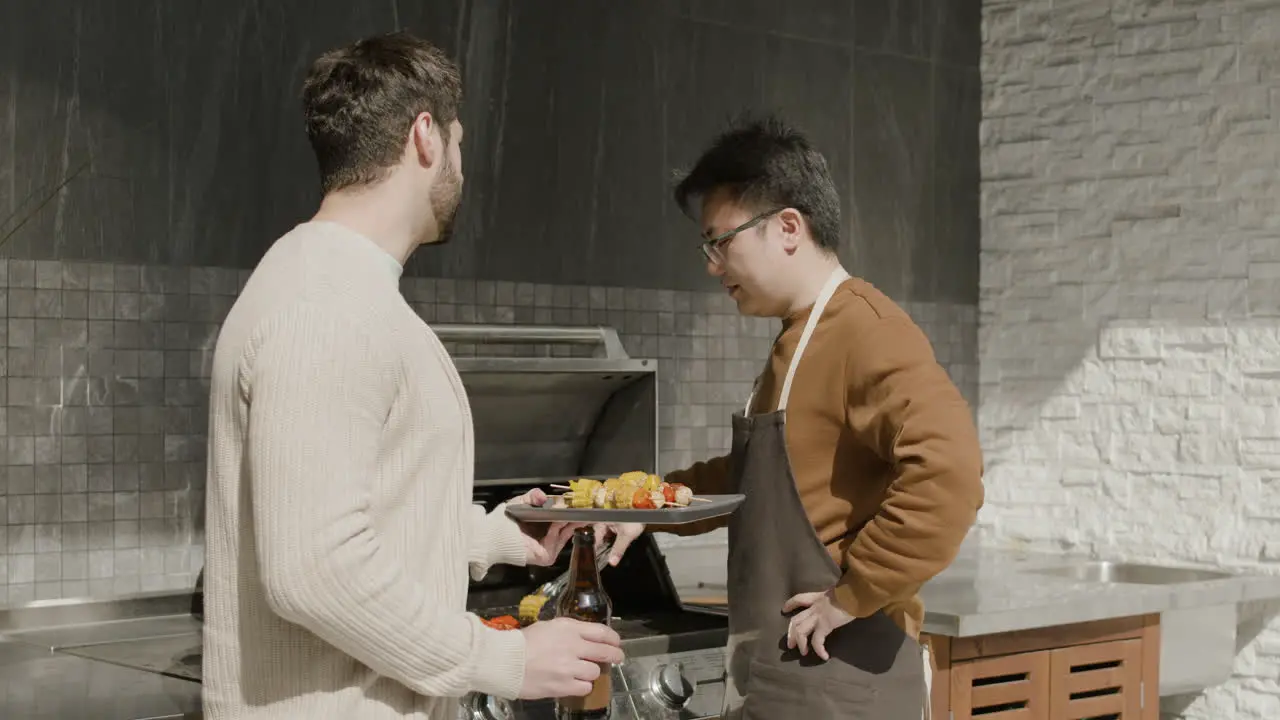 A Young Guy And His Friend Talking While Having A Barbecue