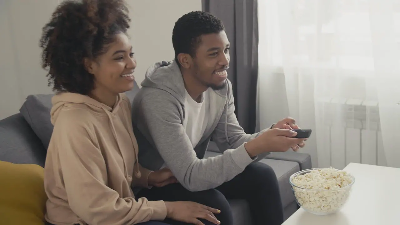 Young Couple Picking A Film With The Remote Control