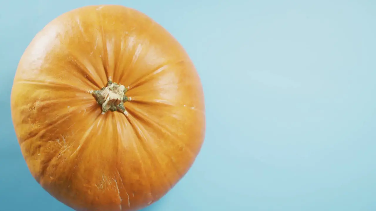 Overhead close up view of halloween pumpkin against blue background