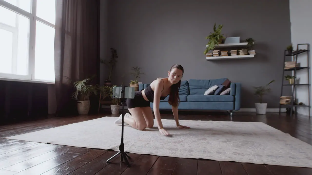 Wide Shot Of A Young Influencer Configuring Her Smartphone Before Her Online Fitness Class