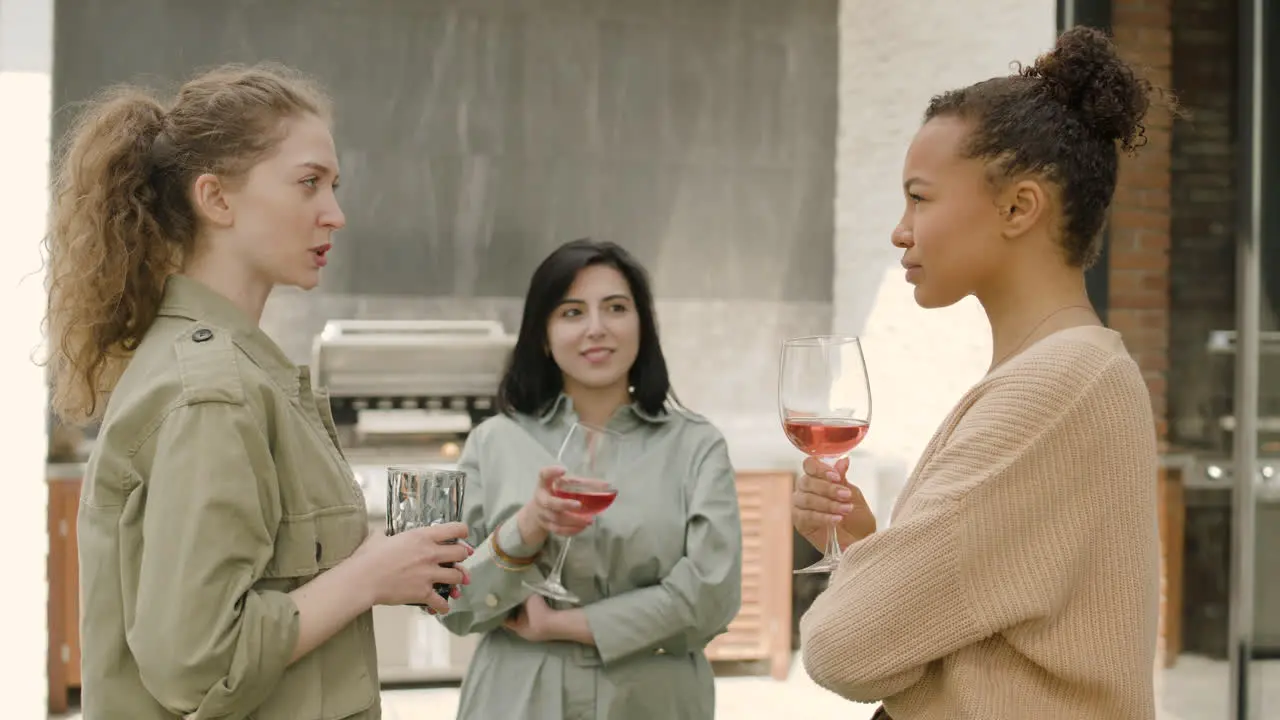 A Nice Multicultural Group Of Three Girls Toast Their Glasses At A Barbecue On The Terrace Of A House