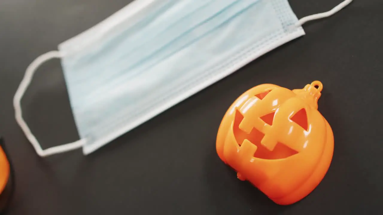 Halloween pumpkin toy and face mask against grey background