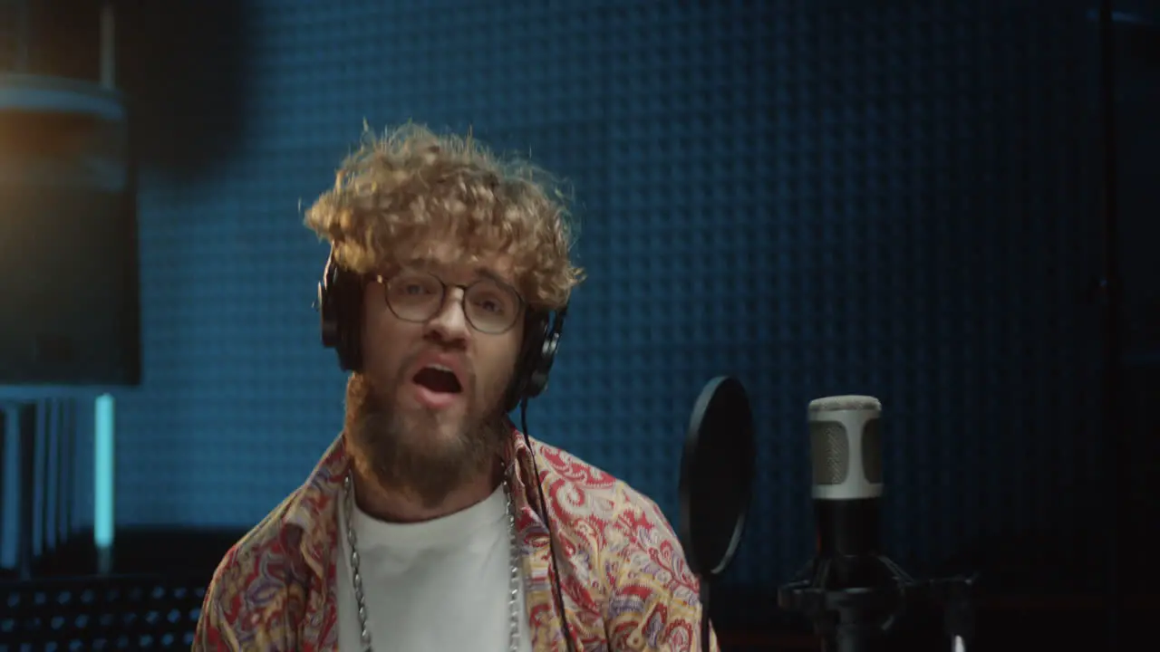 Close Up Of The Young Stylish And Attractive Guy Singer Recording His Solo Vocal And Singing In The Microphone At The Studio