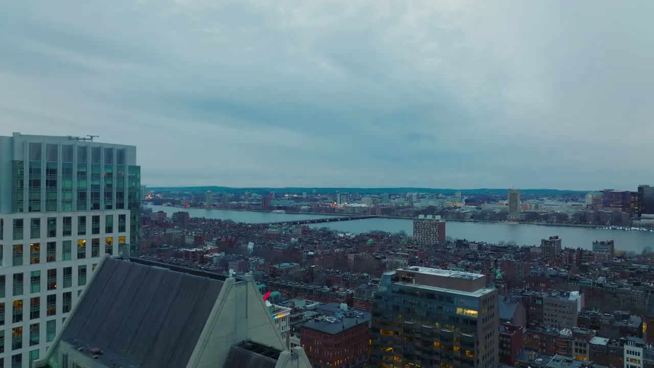 Tight flight around modern high rise building at dusk Revealing panoramic view of Back Bay borough on Charles river waterfront Boston USA