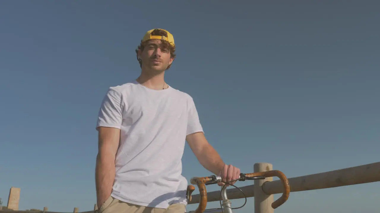 Man With Bike Walking Down The Boardwalk Looking At The Camera