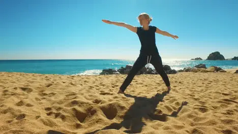 Woman practicing yoga asana on coast of sea Fit girl doing flexibility exercise