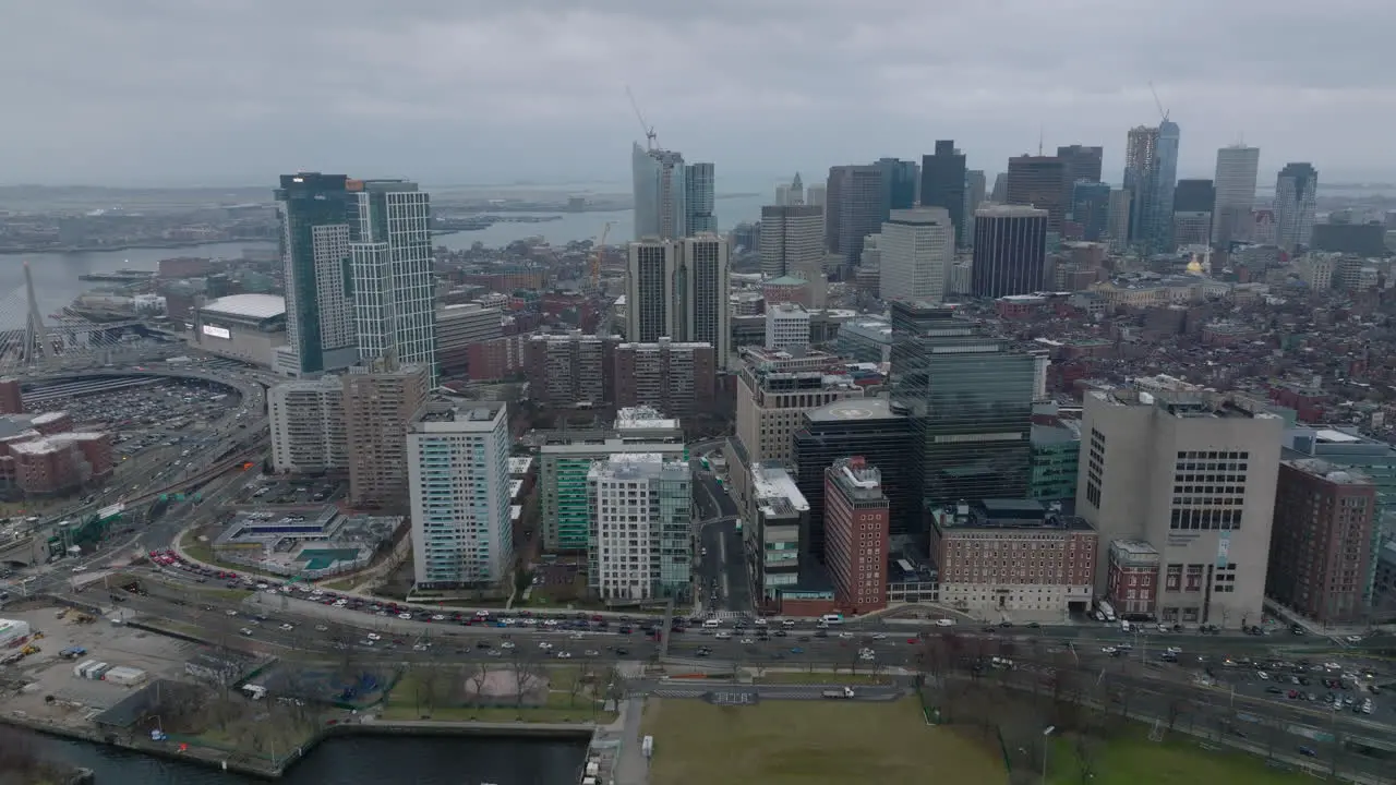 Aerial shot of buildings in Massachusetts General Hospital area and downtown office towers in background Backwards reveal of busy road on waterfront Boston USA