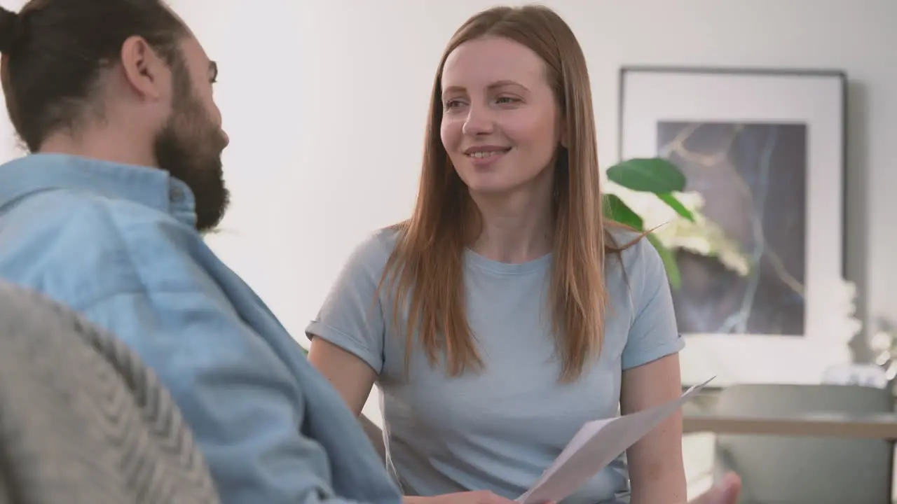 Bearded Man And Beautiful Woman Have A Relaxed Conversation Sitting On The Sofa 2