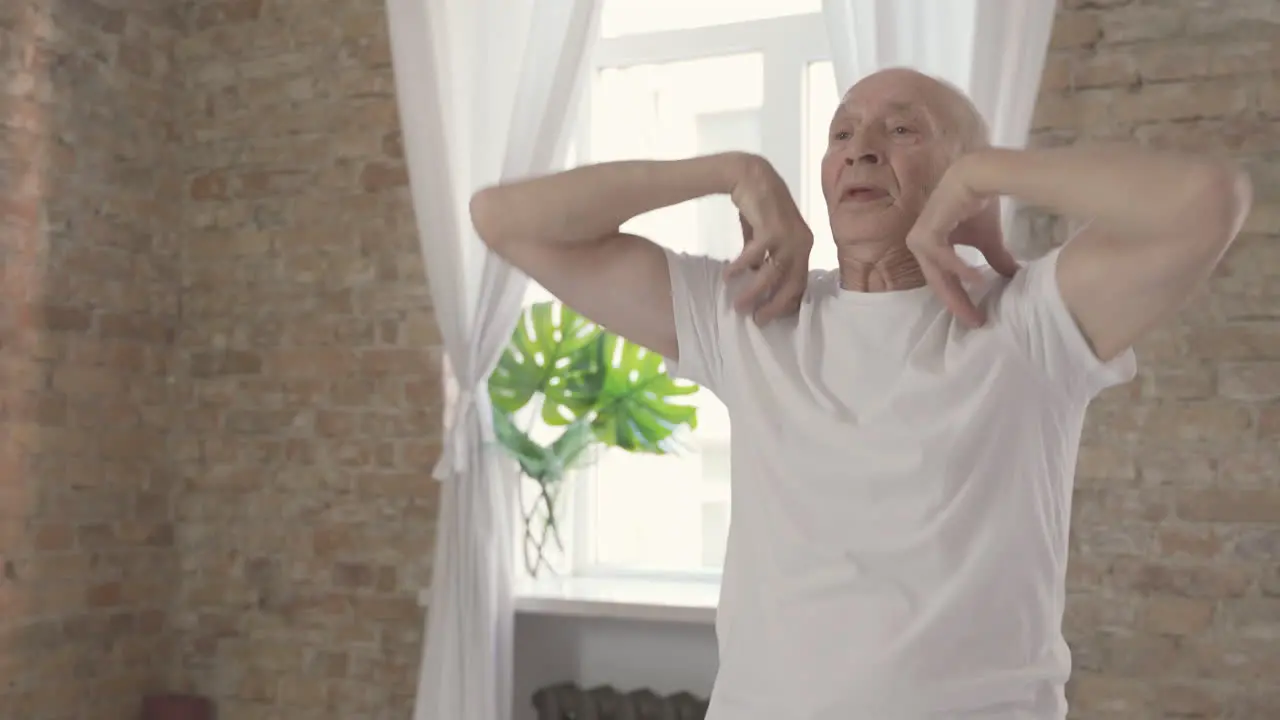 Old Male Exercising And Stretching At Home Close Up