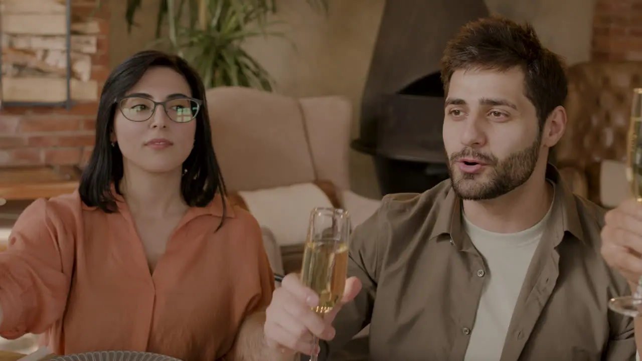 A Group Of Friends Toast With Their Glasses At A Dinner Party