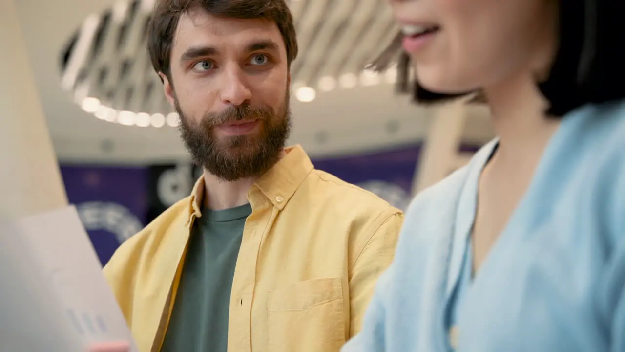 A Man With Glasses Has A Business Meeting In A Coffe Shop With An Unrecognizable Young Woman