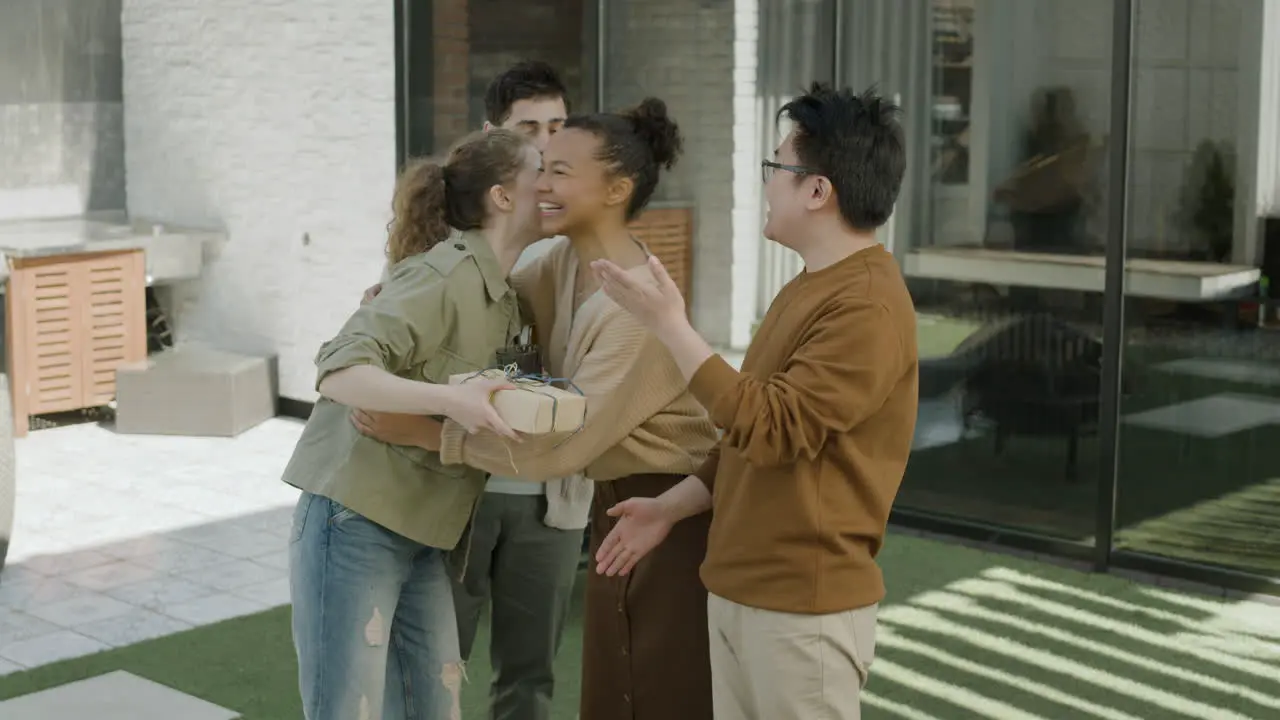 A Multicultural Group Of Friends Greets Each Other As They Arrive At A Barbecue