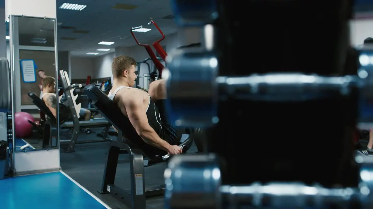 A young athlete trains his legs in the gym 1