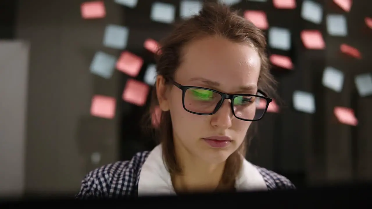 Young Woman In Glasses Working At A Laptop In The Office