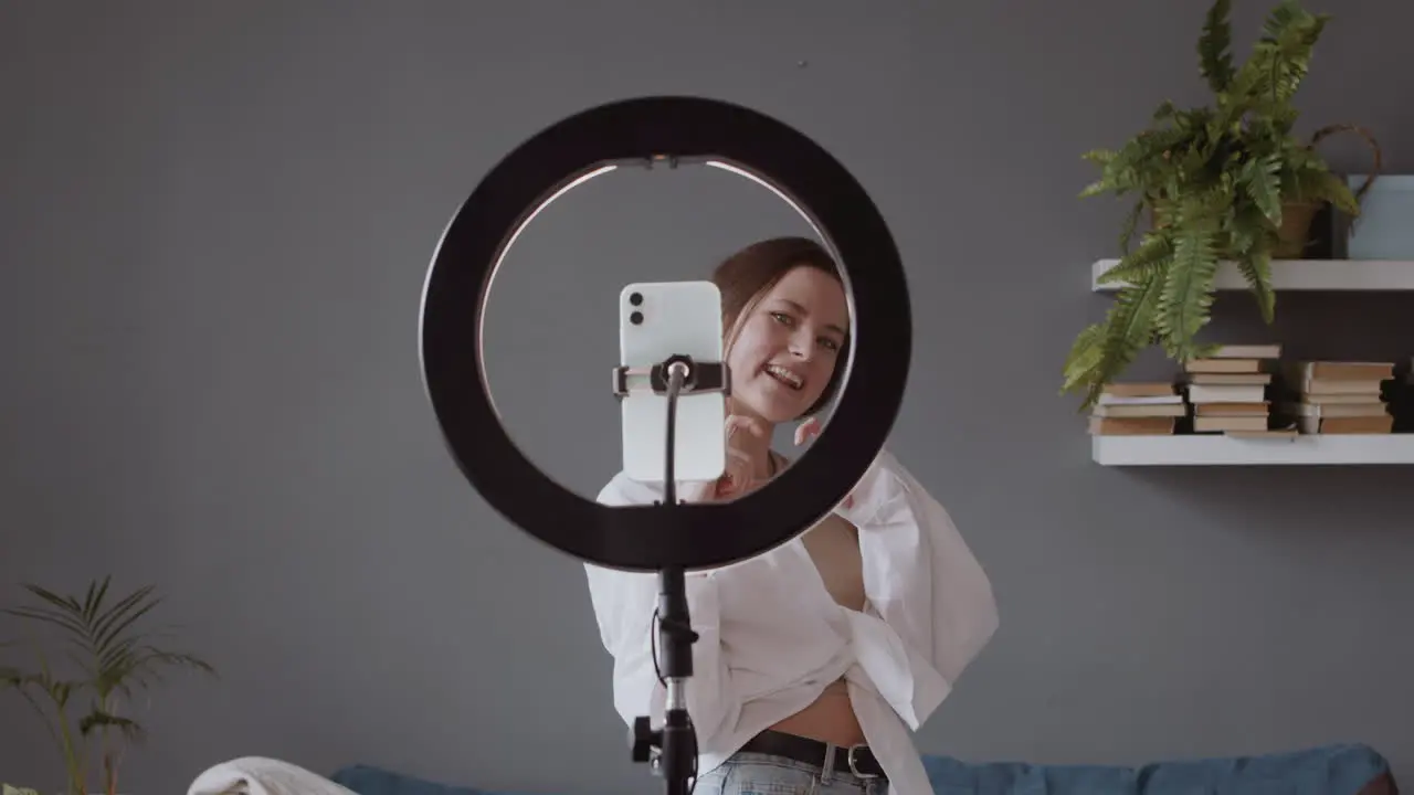 Smiling Young Woman Sending Kisses And Dancing In Front Of Her Smartphone Camera To Upload It To Social Media