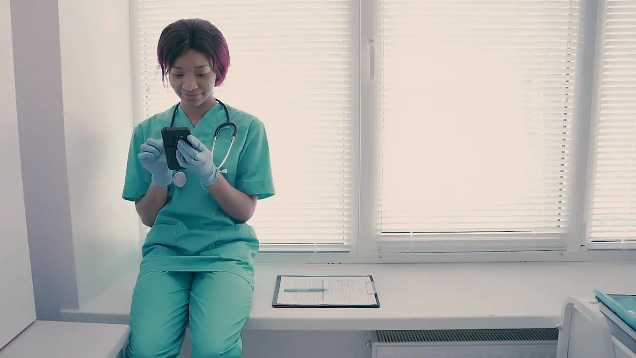 A Beautiful Young Female Nurse Texting On Her Phone