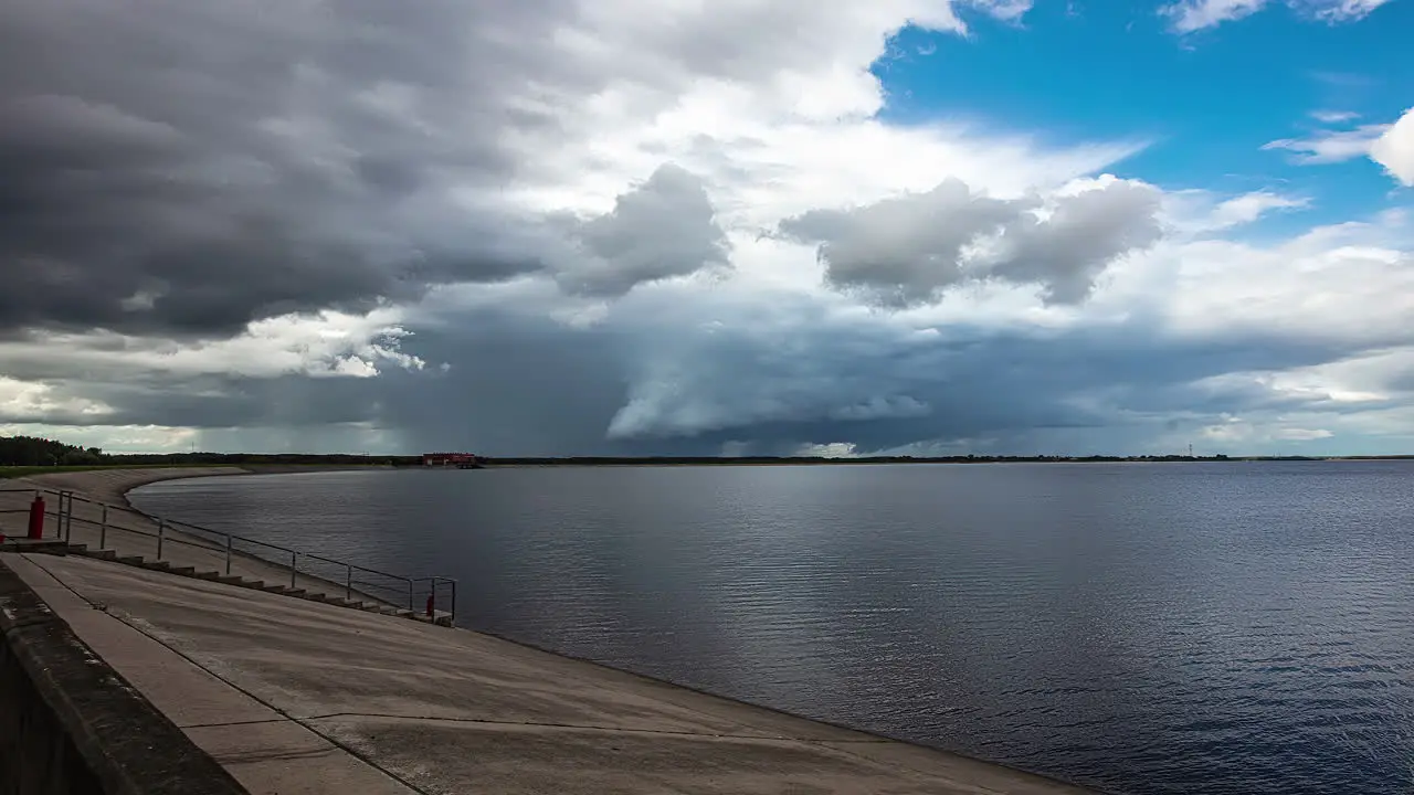 Dark clouds cover tranquil lake after good weather Timelapse