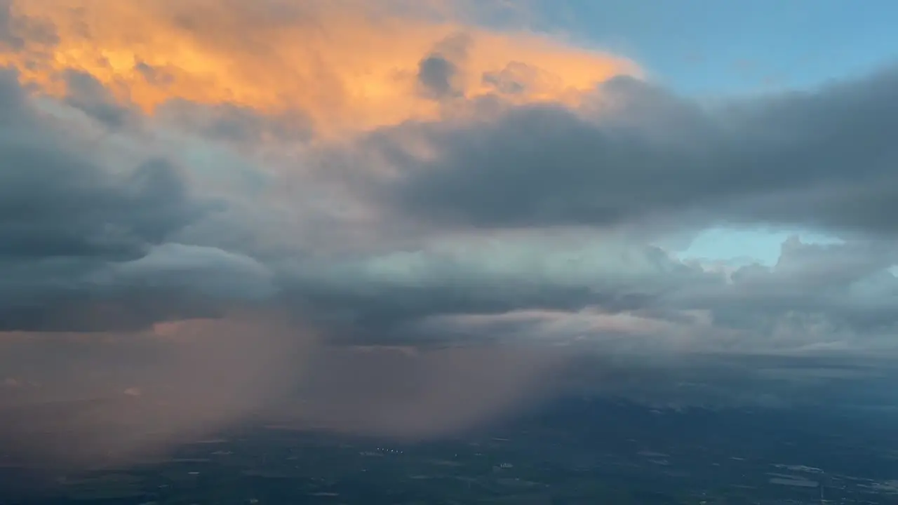 Aeral view from a jet cockpit approaching to Seville airport of a huge cumuloninbus while rainning with orange clouds