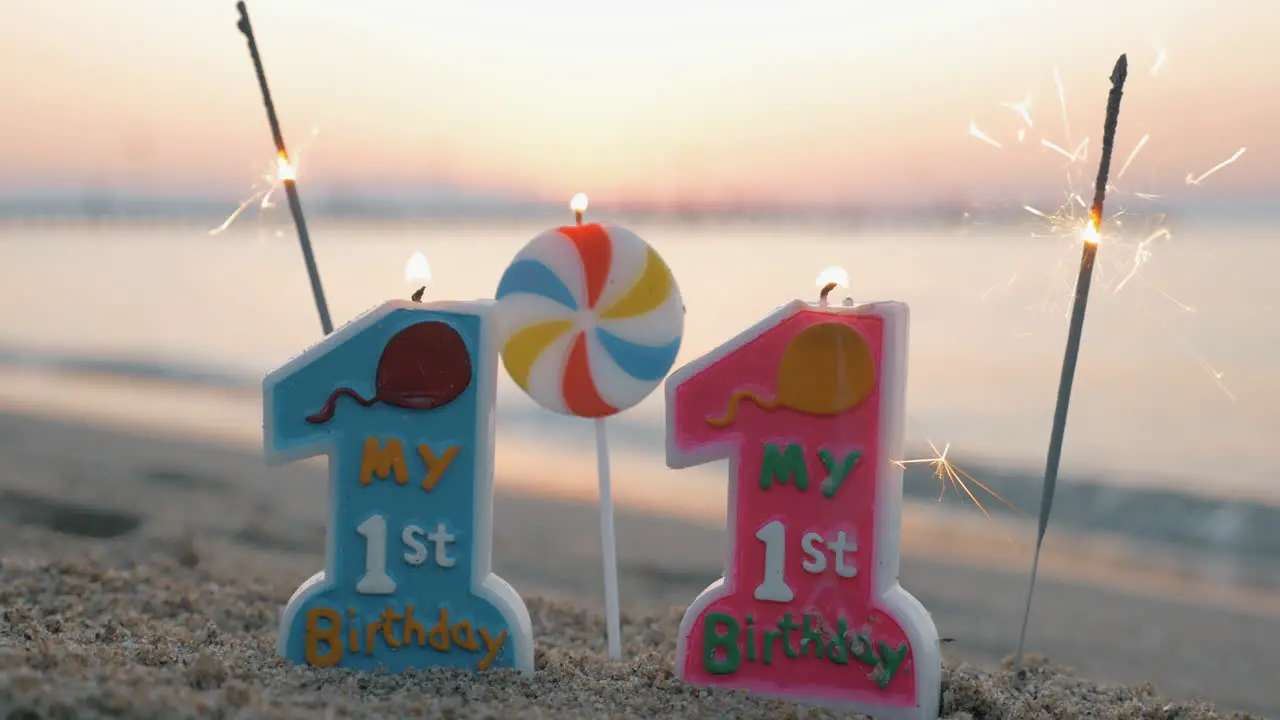 Twins birthday candles and sparklers on the beach