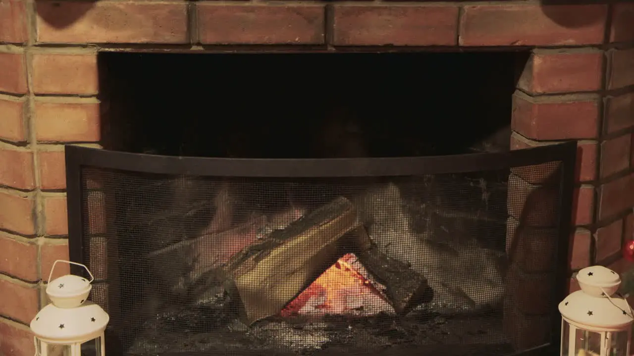 Christmas gift socks hang over the fireplace where the fire burns 3