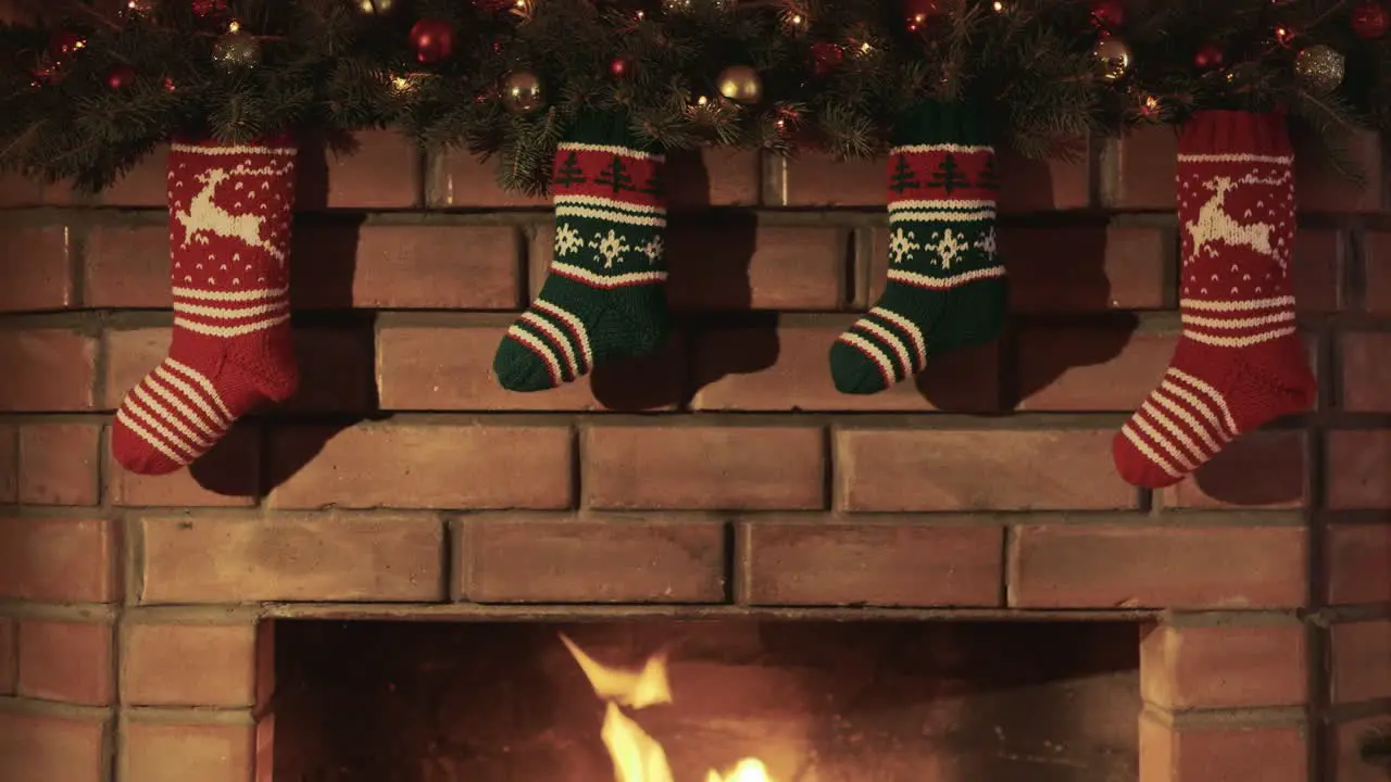 Christmas gift socks hang over the fireplace where the fire burns