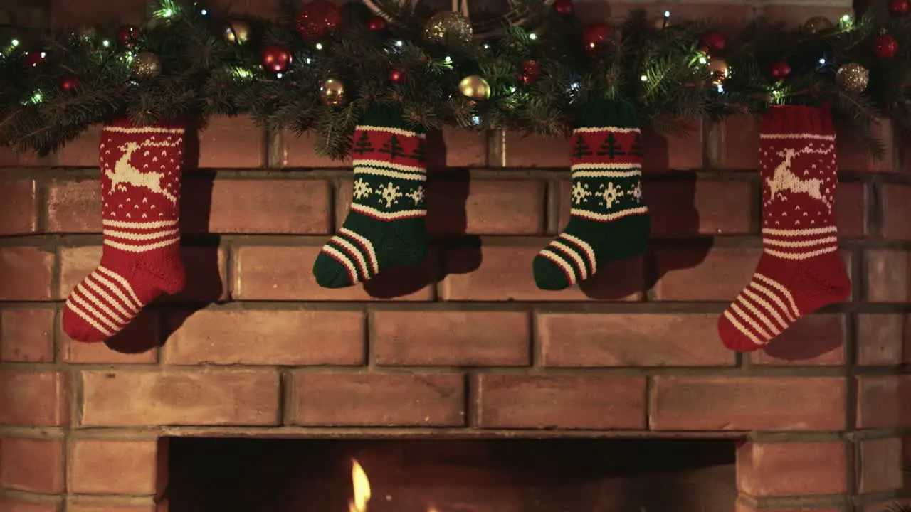 Christmas gift socks hang over the fireplace where the fire burns 2