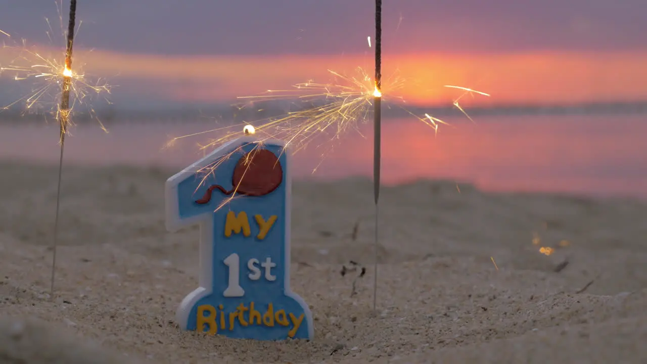 One year old baby boy birthday candle on the beach