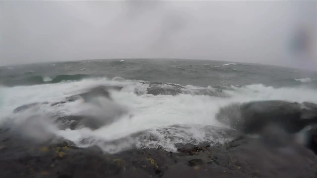 Slow motion shot of large waves breaking on the rocky shoreline of Lake Superior