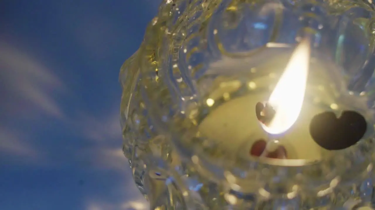 High angle view of a scented candle burning inside a glass flask