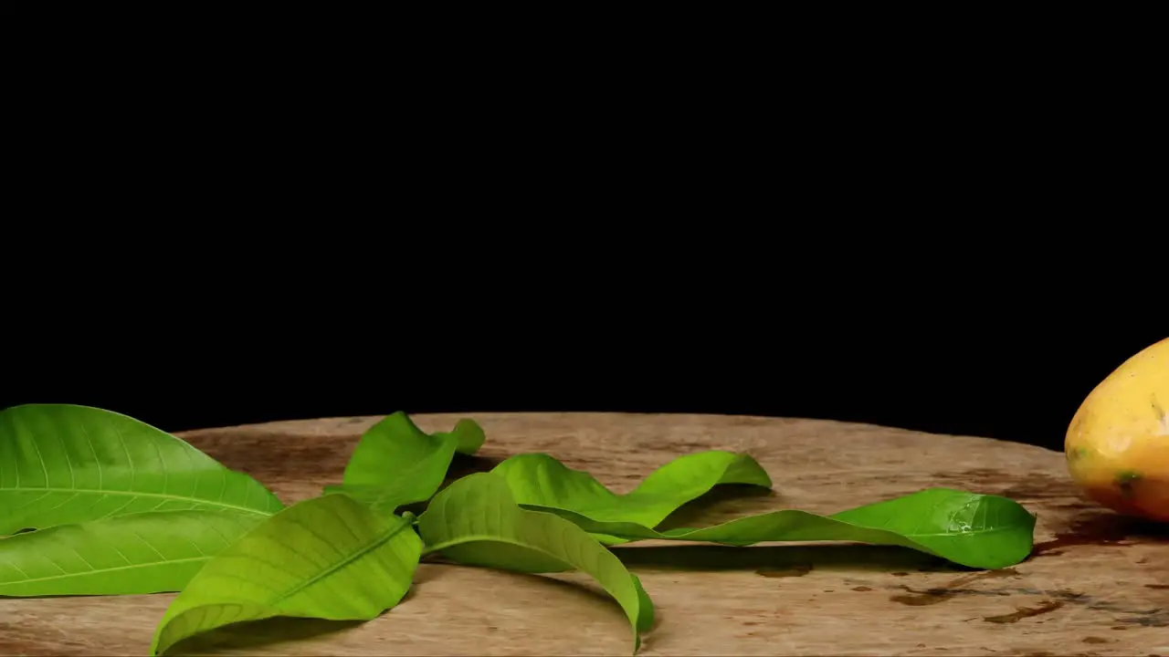 Fresh mango juice is poured in a jug next to the wooden box full of mango on the background time lapse 4k