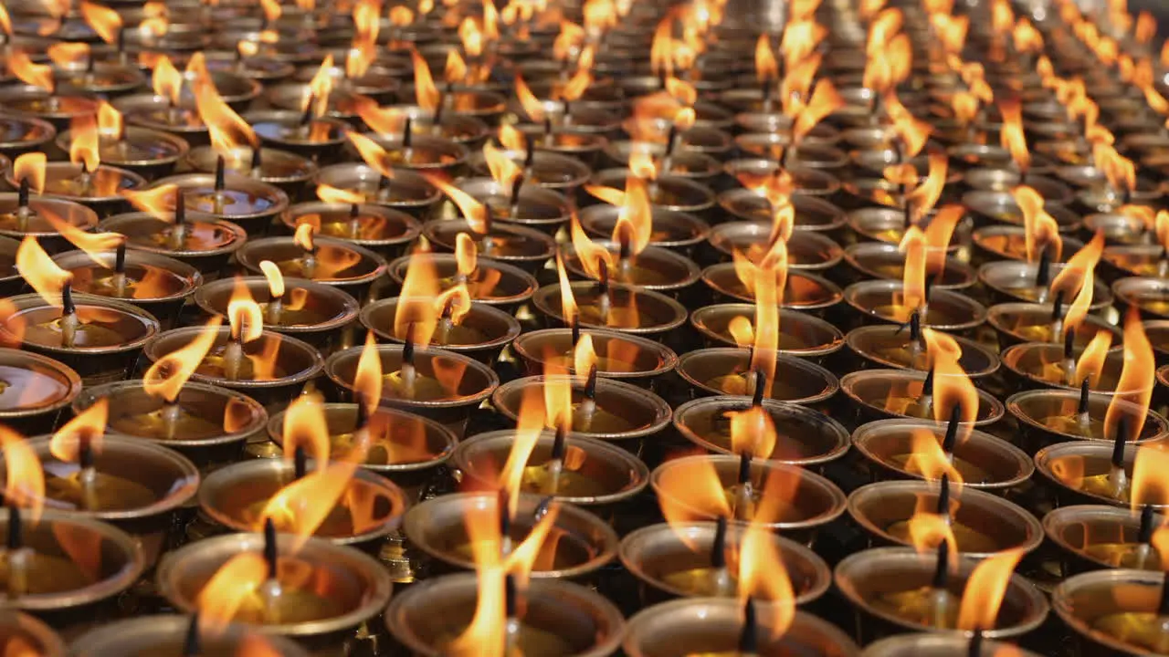 Rows of candles flickering slowly in a monastery in Nepal