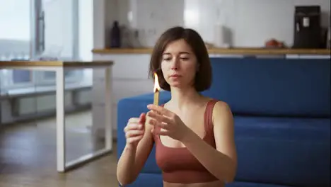 Woman lighting a fire incense herbs and incense waving it