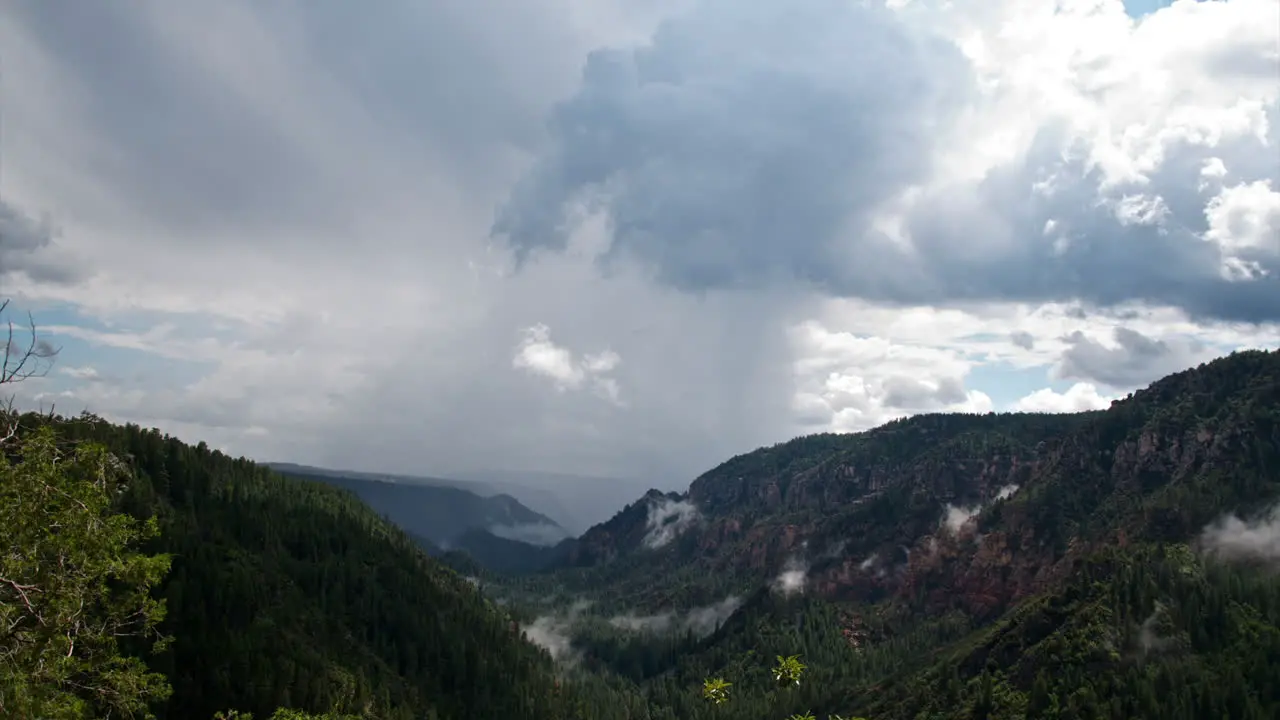 Storm clouds rolling over a green canyon landscape -Time lapse