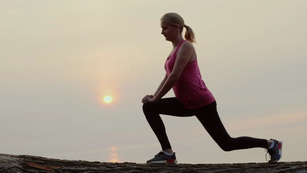 Active Middle-Aged Woman Is Training Against The Backdrop Of The Sea And The Rising Sun