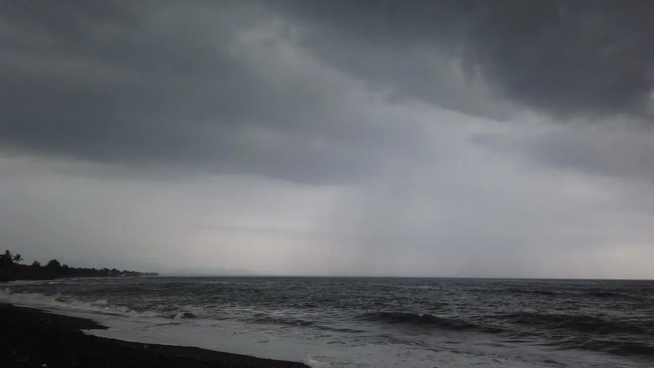 Black Sand Beach with Dark Rainy Cloudy Sky Storm Approaching Black Heavens in Saba Beach Gianyar Bali Indonesia