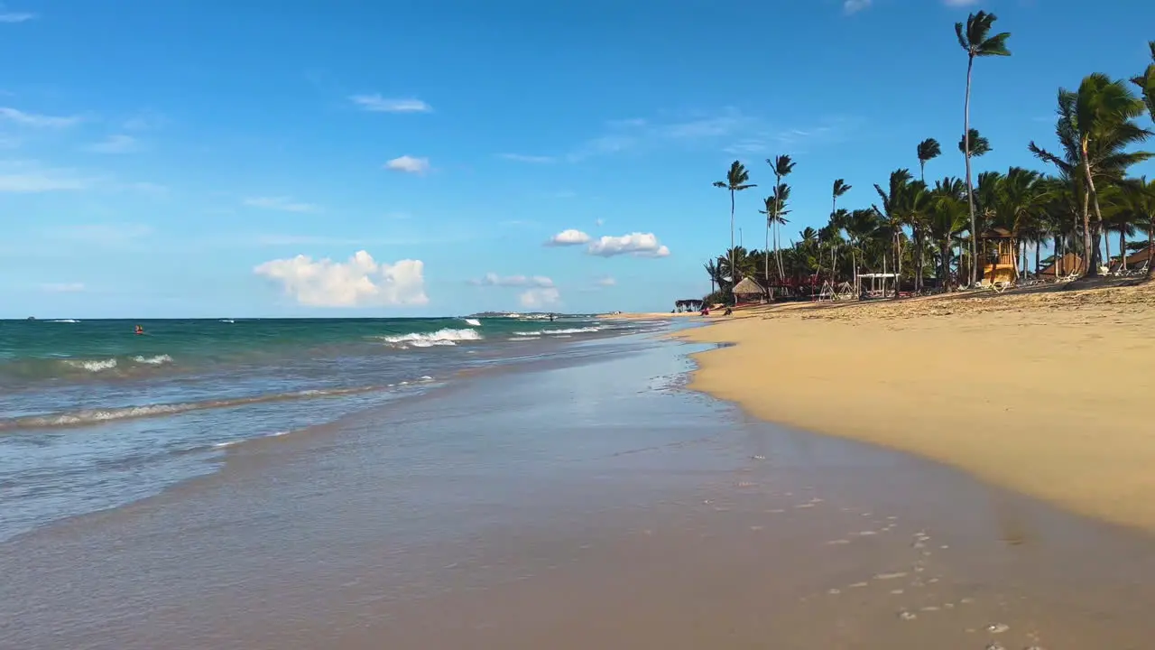 waves roll unto the sandy beach lined with palm trees in Punta Cana Dominican on the island of Hispaniola