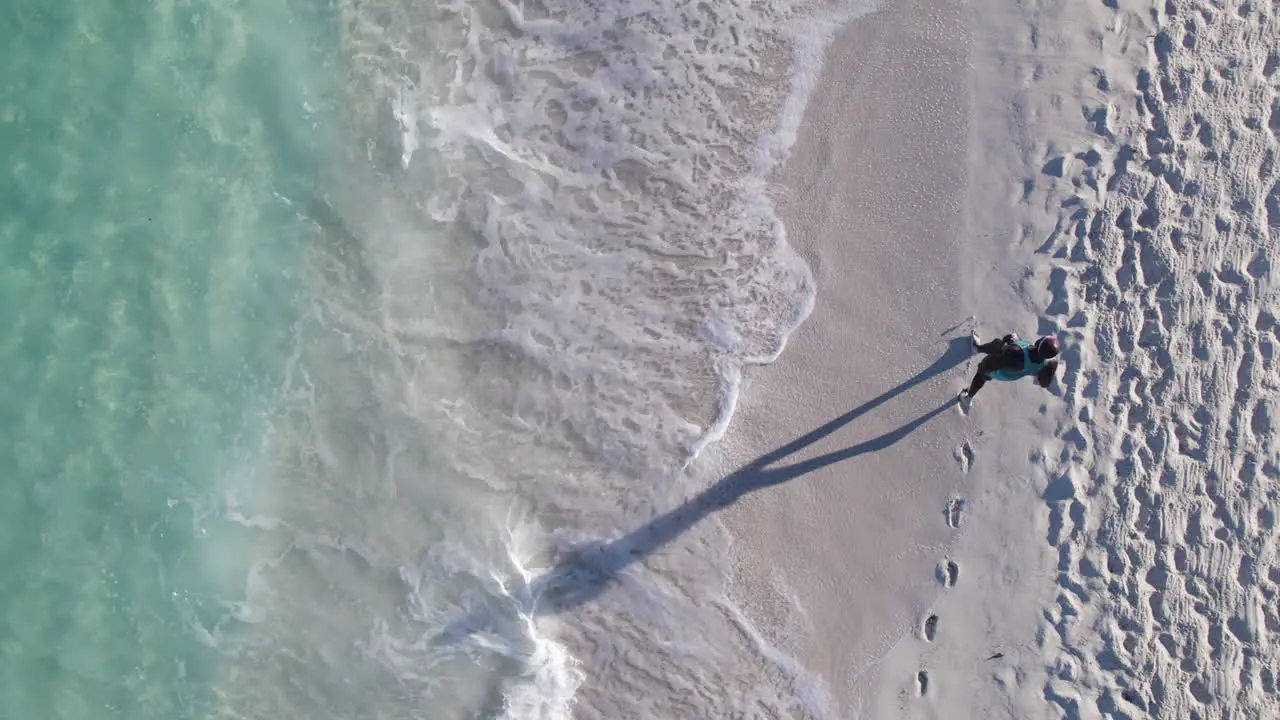 A solo runner jogs on the shoreline while in the Caribbean