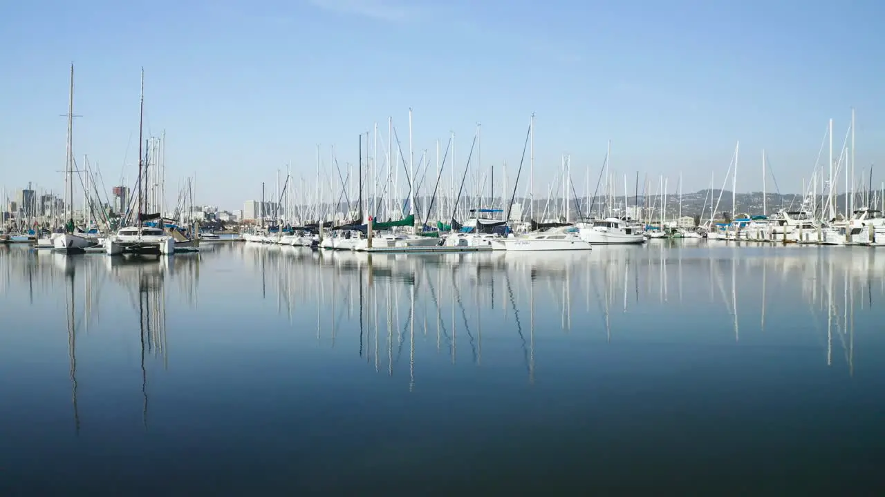 A clean pan right over glassy smooth waters as the boats glisten in the sunny bay