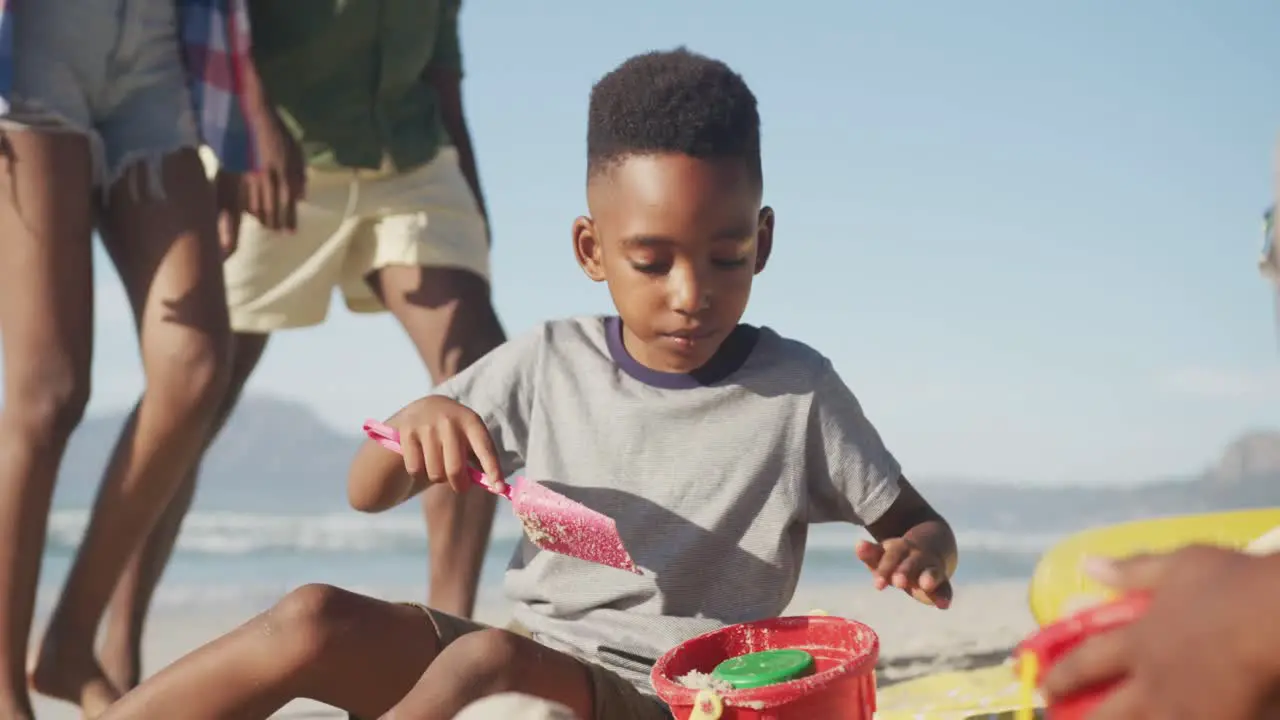 African american boy playing in the sand on the beach