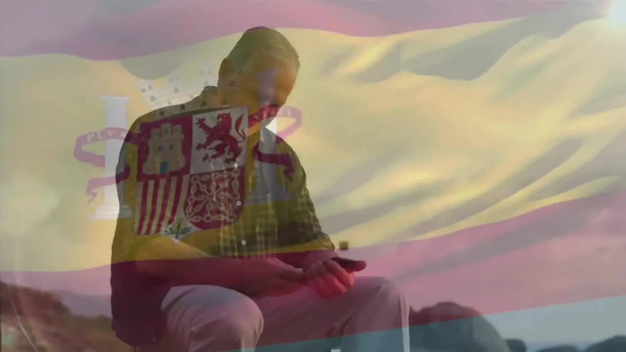 Animation of flag of spain over caucasian man at beach