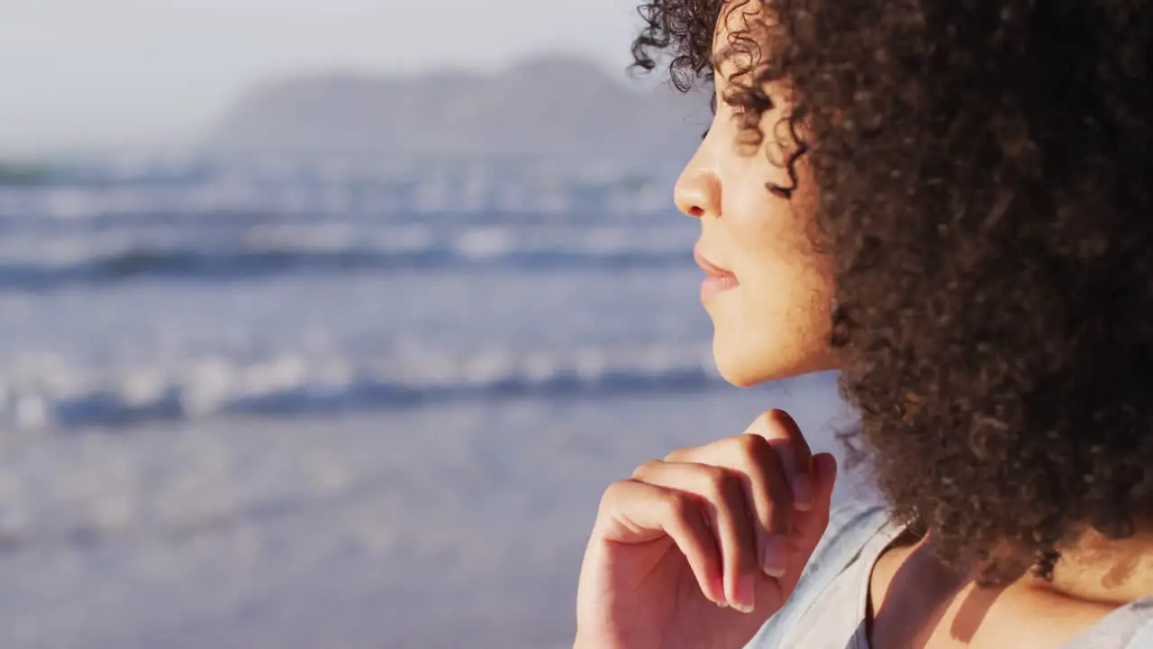 Close of up of african american with hand on chin smiling at the beach