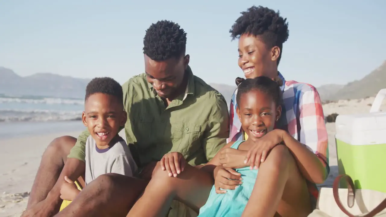 Portrait of african american family smiling while sitting on the beach