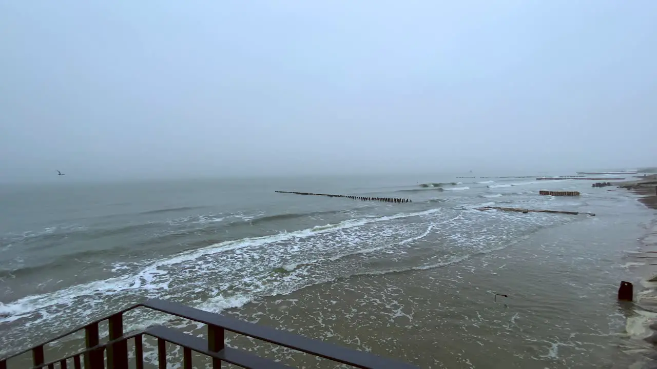 Panning of sea and cloudy and cold beach in winter on city of Mielno