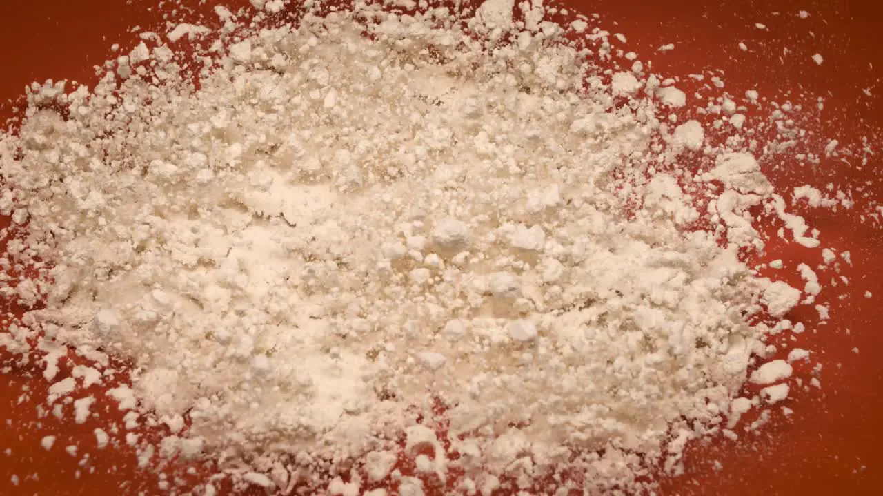 Protein Powder bouncing on orange background in super slow motion