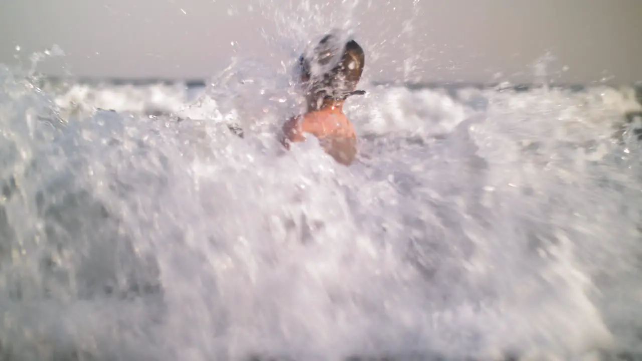 Child bathing in the sea and waves hit him