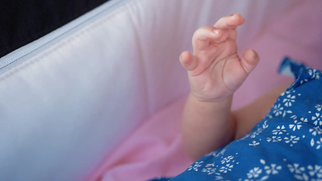 Baby in pram moving her hand