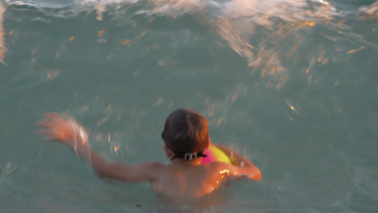 Child bathing in the sea and catching strong waves